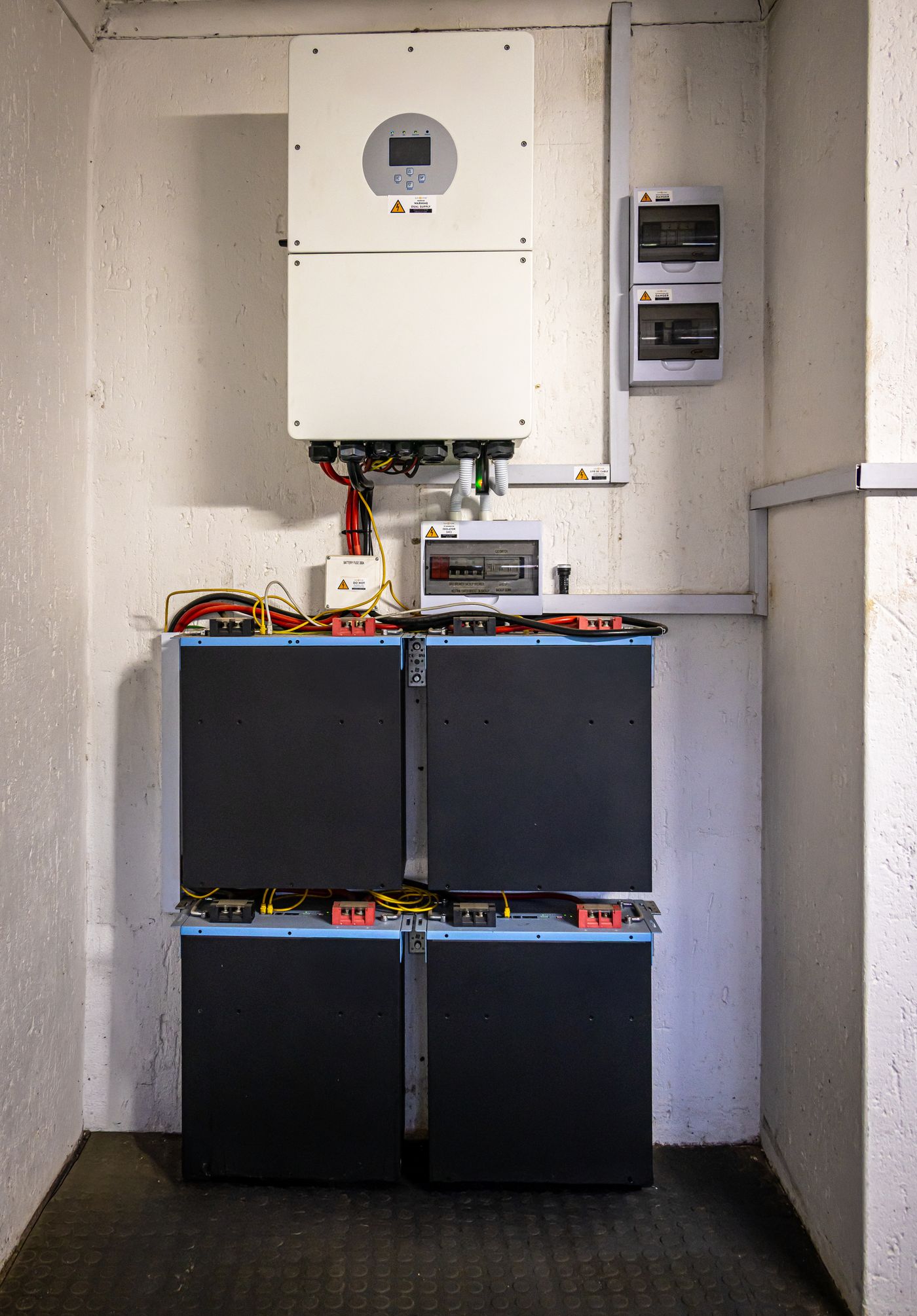 Inversor híbrido y baterías instalados en un cuarto de máquinas